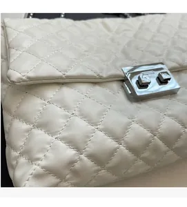 Detail of white quilted handbag featuring soft faux leather and silver metal twist lock