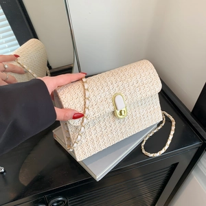 Fashionable summer straw crossbody bag in cream color with gold clasp and chain strap