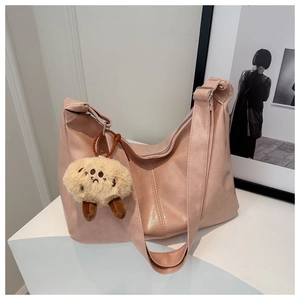 Close-up of pink faux leather hobo tote bag featuring a cute plush biscuit keychain charm