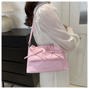 Detail of pink faux leather underarm bag with decorative bows and Fashion & Bags text