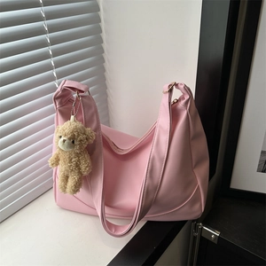 Pink crescent shoulder bag in nylon fabric with a cute plush bear pendant and wide strap