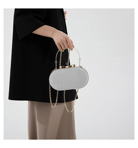 Close-up of silver sequin evening bag with gold ring handle and chain strap for women