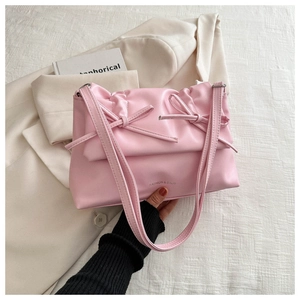 Detail of pink bow shoulder bag with pleated PU leather texture and fashion lettering