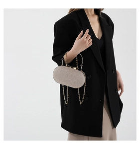 Detail of champagne gold sequined oval evening bag with bow clasp and metal ring handle