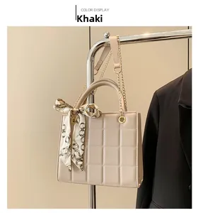 Detail of khaki quilted handbag with printed silk scarf on a metallic hanger