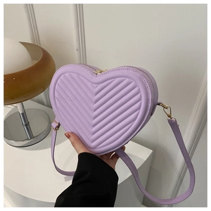 Detail of purple heart-shaped crossbody bag with quilted texture and gold hardware