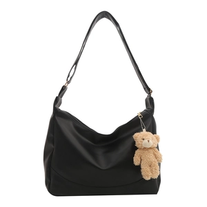 Minimalist black half-moon shoulder bag with a cute brown teddy bear keychain charm