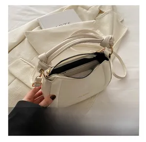 Close-up of white leather handbag interior showing storage capacity and knot handle detail