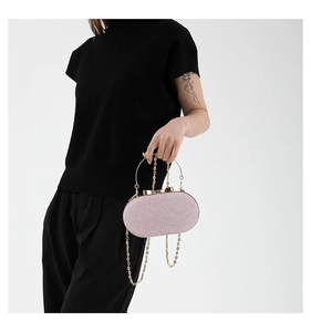 Pink glitter evening clutch bag featuring a gold metal handle and chain shoulder strap