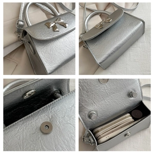 Detail of silver metallic handbag showing bow hardware, magnetic closure and interior space