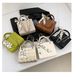Detail view of square quilted handbags in six colors with chain straps and silk scarves