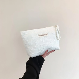 Chic cream canvas makeup bag with heart embossments and pearl strap for travel