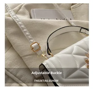 Close-up of a white quilted chain bag featuring an adjustable gold metal buckle