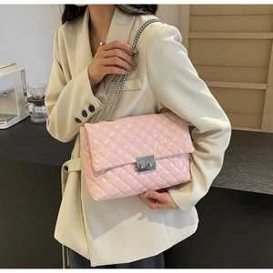 Close-up of pink quilted crossbody bag with silver chain strap and metal turn-lock