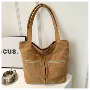 Detailed close-up of khaki corduroy tote bag showing vertical zip pockets and texture