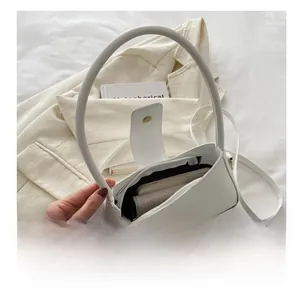 Internal view of white baguette bag showing capacity for phone and wallet with metal buckle