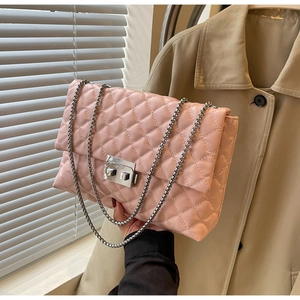 Detail of pink quilted handbag with silver chain strap and metallic twist lock clasp