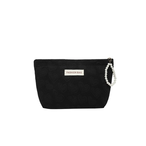 Black quilted mini crossbody bag with heart pattern embossing and pearl ring zipper pull