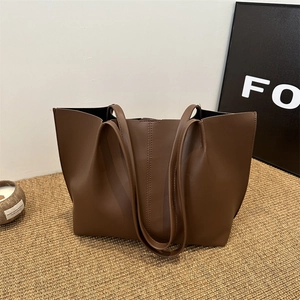 Minimalist deep brown faux leather tote bag with vertical stitching for daily commute