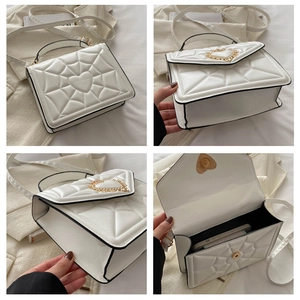 Detail view of white heart-embossed crossbody bag with golden buckle and phone storage