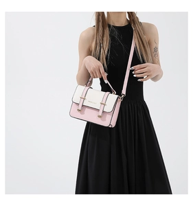 Detail of pink and white crossbody bag with gold hardware shown on a black dress
