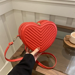 Minimalist red heart-shaped crossbody bag with V-quilted faux leather and gold hardware