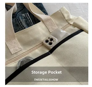 Detail of canvas tote bag showing a convenient storage pocket with a smartphone inside