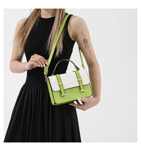 Detail of color-block lime green handbag with white flap and gold metal hardware
