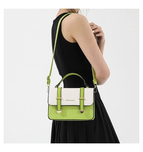 Detail showing neon green and beige contrast crossbody bag with gold metal buckle accents