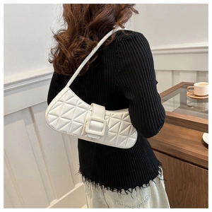 Vue détaillée du sac baguette blanc matelassé avec boucle gainée de cuir porté à l'épaule
