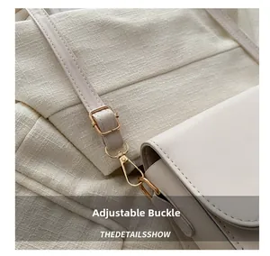 Detail of light beige leather shoulder bag showing adjustable gold buckle and stitching