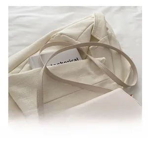 Detail of off-white crossbody bag featuring a golden metal buckle and sleek leather texture