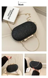 Detail of black glitter evening clutch featuring golden bow clasp and round metal handle