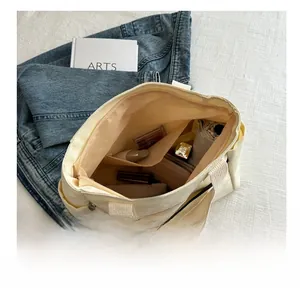 Interior detail of a canvas tote bag showing spacious compartments and zip pocket for storage