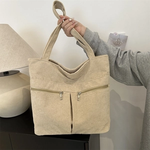 Minimalist beige corduroy tote bag with dual front zippers and wide shoulder straps