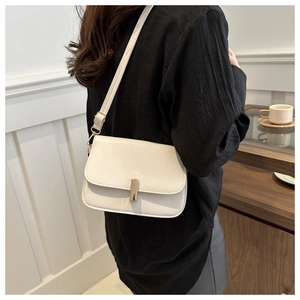 Detail of cream white PU leather crossbody bag with elegant gold metal twist lock closure