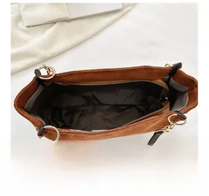 Structure interne du sac fourre-tout en daim marron avec poche zippée et détails dorés