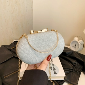 Silver sequin clutch bag with golden bow clasp and chain strap for evening parties