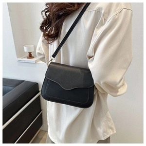 Classic matte black crossbody bag for women with round flap and leather strap shown on model