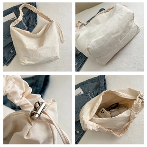 Detail of off-white nylon crossbody bag featuring ruffled strap and silver cord lock