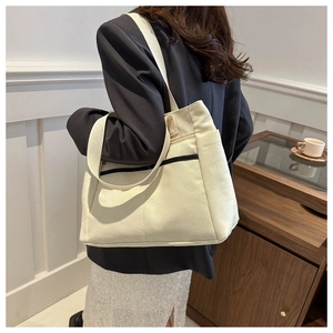 Dettaglio di una borsa tote in tela bianco avorio con strisce nere e ampia capacità