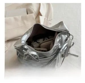Detailed interior view showing large capacity of the silver metallic bow shoulder bag
