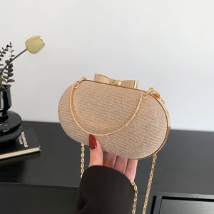 Elegant champagne gold evening clutch bag with bow clasp and gold chain strap