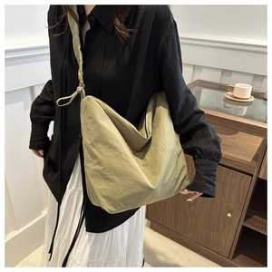 Detail of the olive green nylon hobo bag with knotted strap and pleated texture