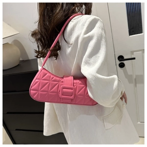 Détail du sac à bandoulière demi-lune rose matelassé avec boucle carrée sur blazer blanc