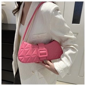 Gros plan sur un sac bandoulière rose fuchsia matelassé avec des coutures de haute qualité