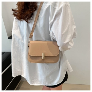 Detailed side view of apricot PU leather flap bag with gold metal buckle and strap