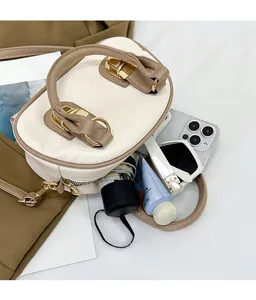 Top view of open minimalist leather crossbody bag showing spacious interior and daily items