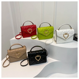 Detail view of five colors of quilted mini square bags with golden heart crown clasps