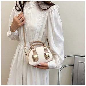 Mini oil wax leather Boston bag in cream and brown styled with a white lace dress